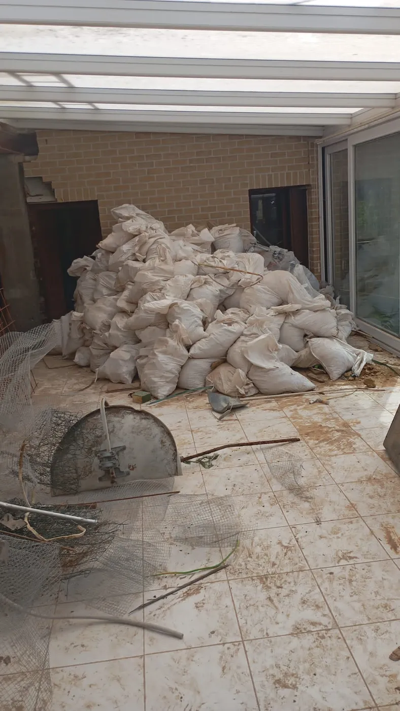Gros tas de sacs de gravats sur une terrasse après une démolition.