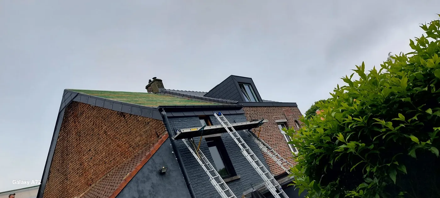 Chantier de toiture avec échafaudage et échelles sur façade en briques