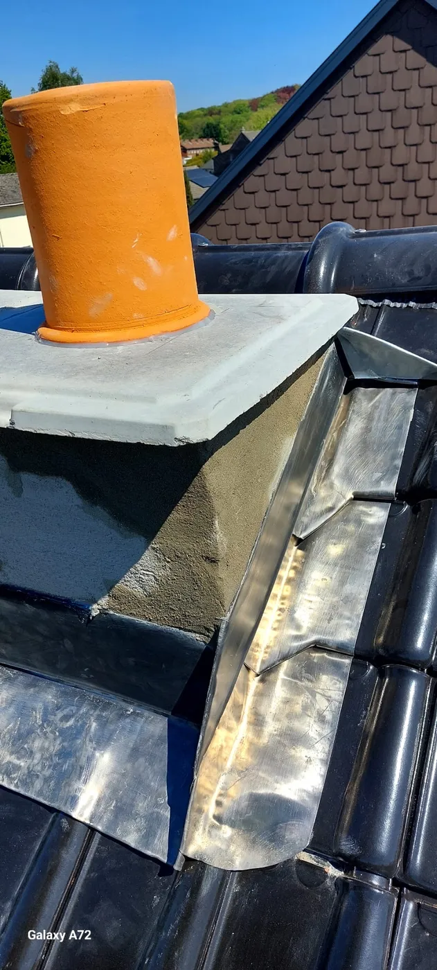 Souche de cheminée et solins en zinc sur une toiture rénovée